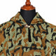 Sage and rust camo alpaca wool poncho – close-up of the neckline with wooden button and loop closure and the woven texture