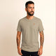 Man wearing a beige t-shirt with an logo on a beige background