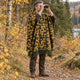 Camo Inti alpaca wool poncho – man birdwatching with binoculars in an autumn forest, wearing the mustard gold, olive and black camouflage hooded poncho