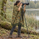 Camo Puyu alpaca wool poncho – wildlife photographer with a camera on a tripod at the lakeshore, wearing the sage and rust camouflage poncho