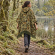 Camo Puyu alpaca wool poncho – rear view on a lakeside forest path showing the hood and olive fringe