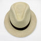 A beige woven straw hat, featuring a dark band, rests on a plain white background, highlighting its classic fedora shape and intricate texture.