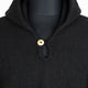 A black knit garment with a single gold button at the collar, displayed on a mannequin torso against a plain background.