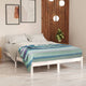 Imbabura baby alpaca wool blanket – bed with white linens and a striped blanket rests against a wood-paneled wall. Two abstract artworks and hanging round lights are present, with a potted plant nearby