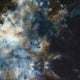 Abstract pattern featuring swirling blue, black, and brown hues with a textured fabric appearance, resembling a cloudy sky or fluid painting. Soft blending creates a dynamic, atmospheric effect.