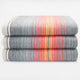 Ajilanga baby alpaca wool blanket – three folded gray blankets with red, orange, and yellow stripes are stacked on each other, set against a plain white background