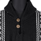 A black-and-white knit sweater with two wooden buttons is displayed on a mannequin. The sweater features patterned vertical stripes, adding a textured look to the garment.