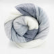 Cayambe baby alpaca wool blanket – a soft blanket, rolled into a spiral, displays a pattern of gray and white stripes. It is set against a plain white background