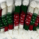 Knit hats with pom-poms are displayed side by side, featuring red, green, and white patterns, suggesting a festive or holiday theme.