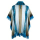 A hooded poncho with turquoise fringe hangs displayed. It features a mix of blue, brown, and beige vertical stripes and patterns, set against a white background.