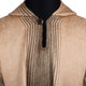 A beige and brown poncho features vertical and diagonal stripes, buttoned at the neck, displayed against a black mannequin torso, showcasing its textured woolen fabric in a neutral setting.