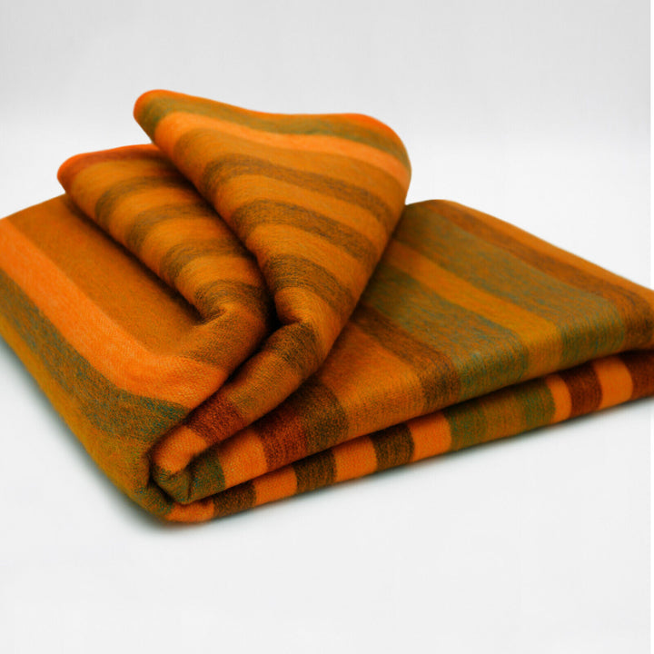 Putumayo baby alpaca wool blanket – a folded, soft blanket with orange and green stripes lies neatly arranged on a clean white surface