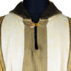 A striped wool garment features beige and brown vertical patterns with a wooden button fastening near the collar, displayed on a black mannequin torso against a plain background.