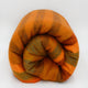 Putumayo baby alpaca wool blanket – a rolled, orange-and-brown striped blanket sits on a white background. The texture appears soft and fluffy, suggesting warmth and comfort