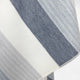 Cayambe baby alpaca wool blanket – a textured fabric with alternating wide and narrow blue and white stripes lies flat without any surrounding context