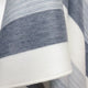 Cayambe baby alpaca wool blanket – a soft, woolen blanket drapes gently, displaying broad stripes in alternating shades of gray and white, against a neutral background