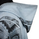A light blue, woolen fabric with dark geometric patterns is shown draped over a mannequin's shoulder, highlighting intricate designs.