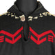 A black sweater with ethnic patterns, featuring red zigzag designs and cream geometric motifs, fastened by a single button at the neck, displayed on a mannequin torso.
