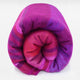 Chone baby alpaca wool blanket – a fluffy, rolled-up blanket features vibrant pink, purple, and red hues, lying against a plain white background