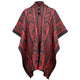Poncho displays red and black geometric patterns, featuring a high collar with button closures, hanging symmetrically. Its intricate design evokes a traditional, cultural aesthetic in a neutral setting.