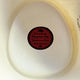 A white Panama hat displays a circular label. The text reads: Premium Panama Hat, Sombrero Fino, HIGH QUALITY with a hat icon and thumbs-up symbol, inside a woven textured pattern.