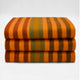 Putumayo baby alpaca wool blanket – three folded, orange and brown striped blankets are stacked neatly against a plain white background