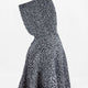 A textured, speckled black-and-white hooded garment is displayed in profile against a plain white background, highlighting the intricate knit pattern and voluminous shape.