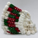 A stack of red, green, and white knit hats with pom-poms is neatly arranged, showcasing a festive pattern, against a plain background.
