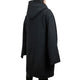 A person wears a long, black hooded coat, viewed from the back, standing in a blank, white space.