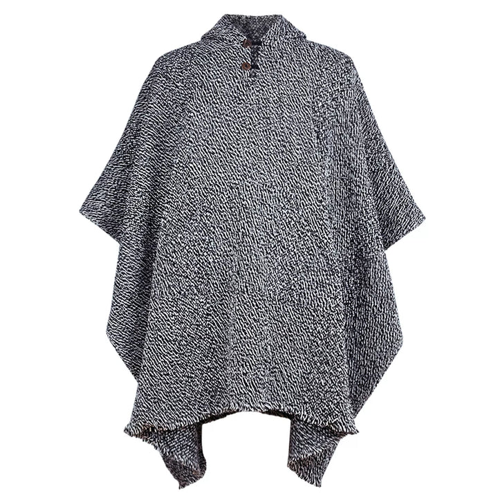 A black and white textured poncho with a high collar and button closure, drapes symmetrically, displayed against a plain, neutral background.