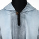A light blue garment with a collar features vertical black stripes and a central brown button, draped over a black mannequin torso.