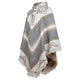 A patterned poncho with geometric designs and buttoned collar drapes elegantly, displaying gray, white, and beige hues, with fringe along the edges. The background is plain white.