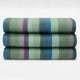 Imbabura baby alpaca wool blanket – three neatly folded blankets with broad horizontal stripes in muted greens, blues, and purples are stacked on one another against a plain white background