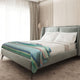 Sucua baby alpaca wool blanket – a plush bed with white pillows and a multicolored striped throw lies in a modern bedroom with light wood paneling and daylight streaming through sheer curtains