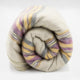 Quijos alpaca wool blanket – a rolled-up wool blanket with purple, yellow, and gray stripes, resting on a plain, white surface