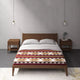 Bed with patterned duvet sits centrally between two wooden nightstands; white pillows are neatly arranged. Pendant lights hang from the ceiling. The room features a minimalist design with muted tones.