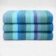 Pululahua baby alpaca wool blanket – three neatly folded blanket with horizontal blue, teal, and purple stripes stacked on a plain, light background