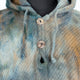 A woolen hooded coat features textured buttons and a multicolored pattern of blues and browns. It is displayed on a mannequin, highlighting its woven, herringbone design.