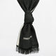 A black scarf with a knotted center hangs against a plain background. It features a small white geometric embroidery near fringed edges.