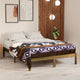 Qhusi extra large alpaca wool blanket – a bed with white pillows and a colorful patterned blanket is situated in a modern bedroom. The room features a wooden wall panel, framed abstract art, and hanging lights