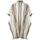 A cream-colored poncho features intricate brown and black geometric patterns along the edges and center, creating a symmetrical design. It's displayed against a plain white background.