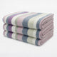 Yunga baby alpaca wool blanket – a pile of three folded, striped blankets with pastel colors, including purple, pink, blue, and white, rests against a plain white background
