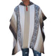 Person wearing a hooded poncho with geometric patterns and vertical stripes, standing against a plain background. The poncho features neutral tones and is paired with ripped jeans.