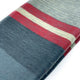 Atacazo baby alpaca wool blanket – a folded striped fabric features wide bands of gray, red, and cream colors, lying neatly on a white surface, displaying a soft texture