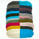 Colorful, fuzzy fabric rectangles lay stacked in two-tone combinations. Each piece features vibrant colors like turquoise, pink, and mustard yellow, arranged neatly on a plain white background.