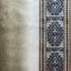 A soft wool blanket displays gray and brown geometric patterns with stripes on the left, creating an intricate design in a neutral color scheme.