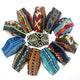 Cloth face masks arranged in a circle display various colorful, geometric patterns. The central mask features black and white designs, surrounded by blue, red, and multicolored masks on a white background.