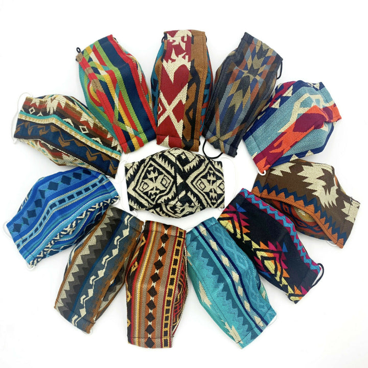 Twelve colorful face masks with tribal patterns arranged in a circle on a white background, with a black and white mask at the center.