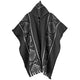 Woolen poncho hangs, featuring geometric patterns in white and gray. It has a high collar with a button, against a plain white background.