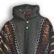 A knitted sweater with a hood hangs on a black hanger. It features geometric patterns in brown, orange, and white on its sleeves and front, with two buttons at the neck.